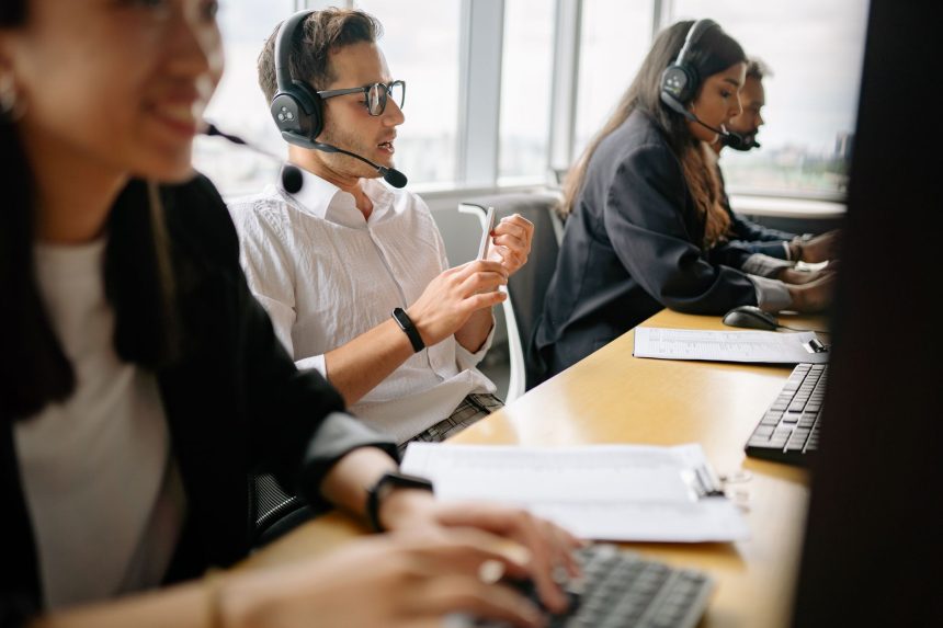 Equipe diversa de atendentes trabalha em um escritório moderno de serviços.